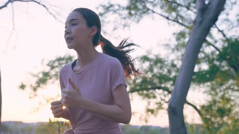 woman running in park at sunset