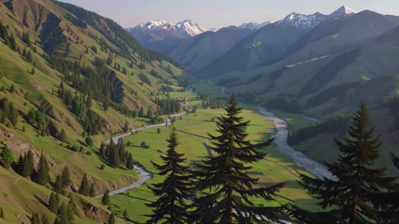 Aerial video view of a lush valley with a winding river, surrounded by mountains