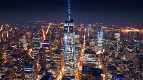 Breathtaking aerial view of illuminated skyscrapers and One World Trade Center standing tall amidst the vibrant cityscape of New York City at night, creating a mesmerizing urban panorama