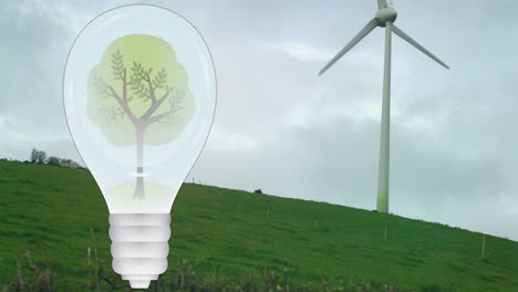 Animation-of-tree-in-light-bulb-over-wind-turbine-in-green-landscape