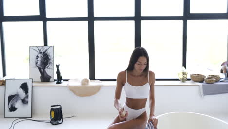 mujer en lencería blanca relajándose en un baño moderno