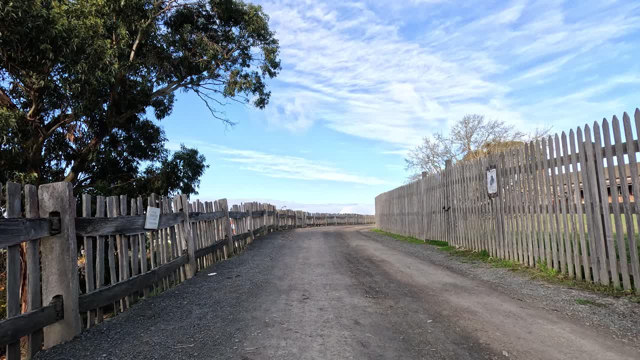 나무 울타리 와 나무 가 있는  도로