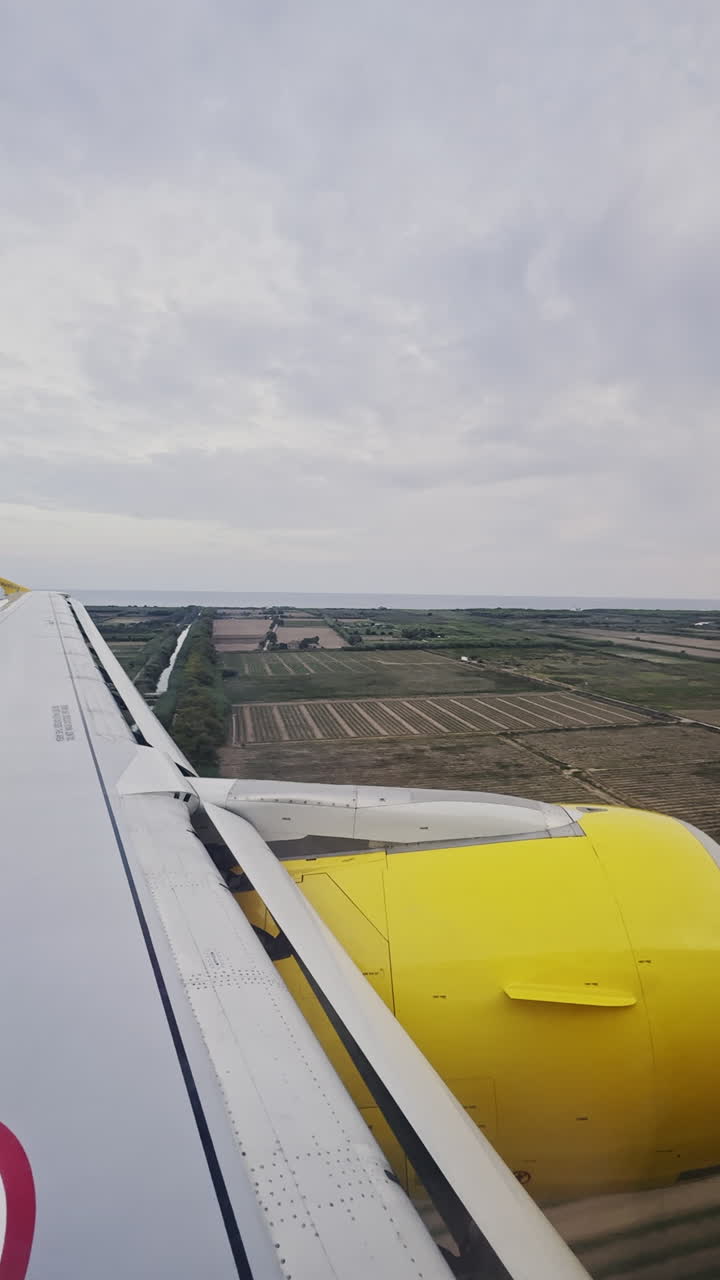 vista desde una ventana del avión mientras aterriza en el aeropuerto disparado en vertical