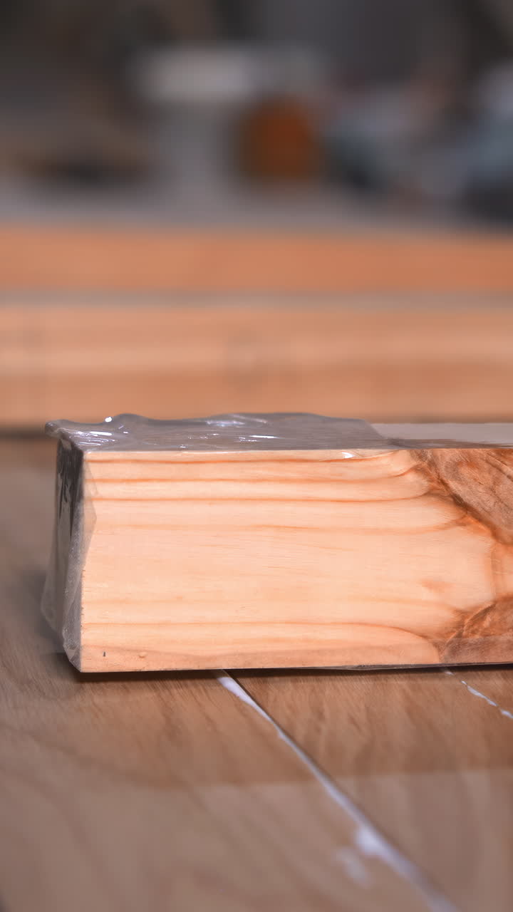 CloseUp Hands Stacking Finished Wooden Boards On Conveyor, Plastic Film Visible For Wrap, Neat Rows Ready. Media
