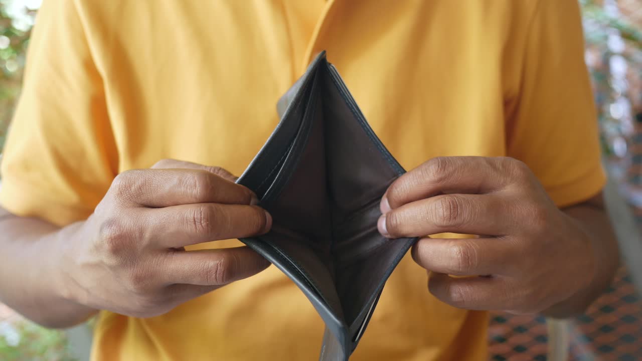 Mano de hombre abre una billetera vacía con espacio de copia