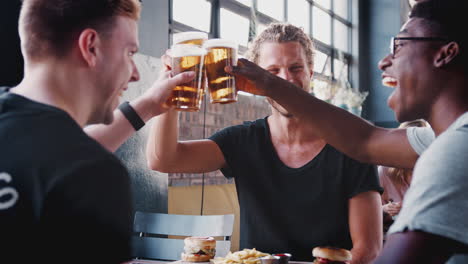 drei junge männliche freunde treffen sich zu getränken und essen, um einen toast im restaurant zu machen