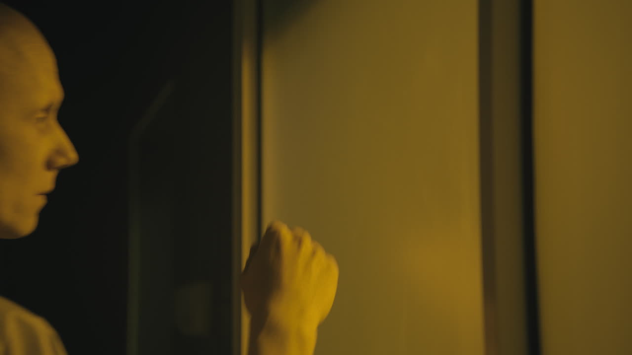 A bald man looks through the yellow glass in the operation room