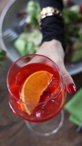 aperol spritz in a hand at a restaurant