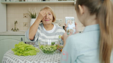 grandmother and granddaughter making salad together