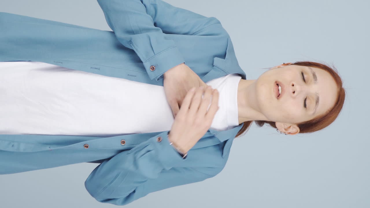 기침을 하는 여성의 수직 영상입니다.