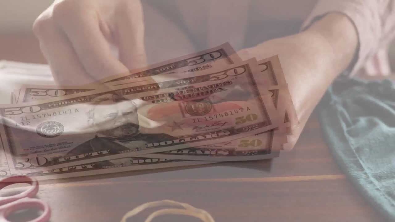 video compuesto digital de un hombre contando billetes de dólar estadounidense contra una mujer cosiendo una máscara facial