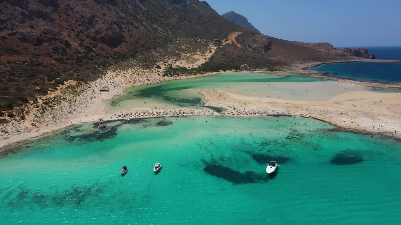 Drone flying over Balos Beach and Lagoon with turquoise water, mountains and cliffs in Crete, Greece