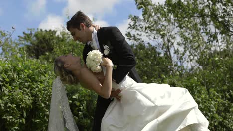 groom kissing his pretty new wife outside