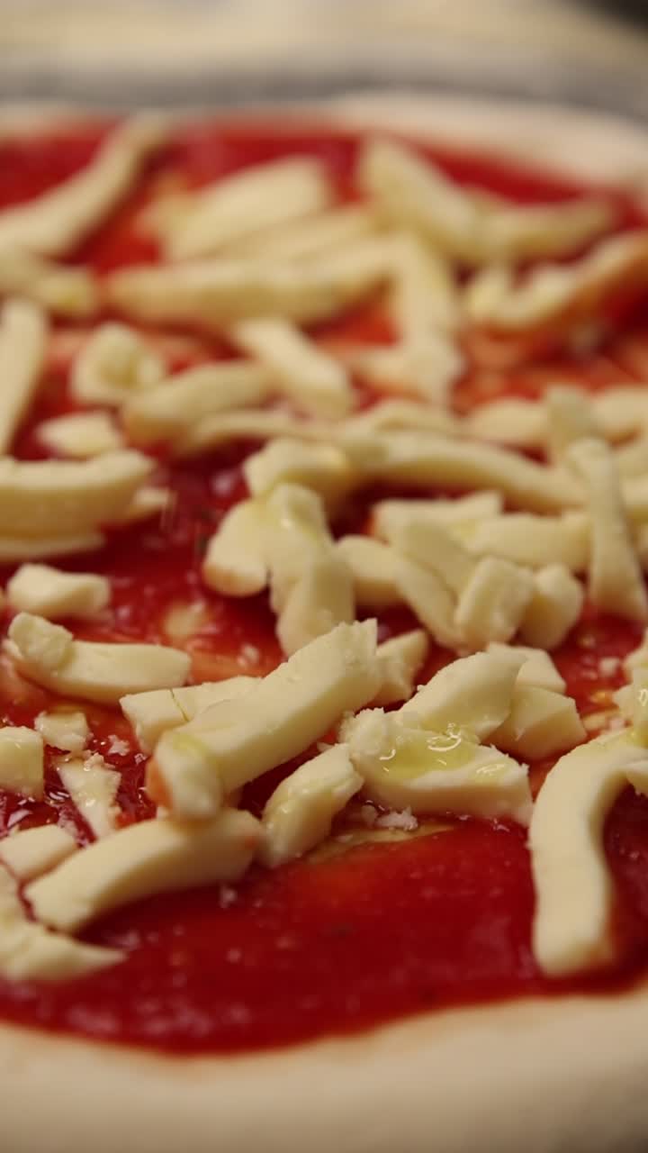 Un filo d'olio d'oliva su pizza cruda con mozzarella e salsa di pomodoro