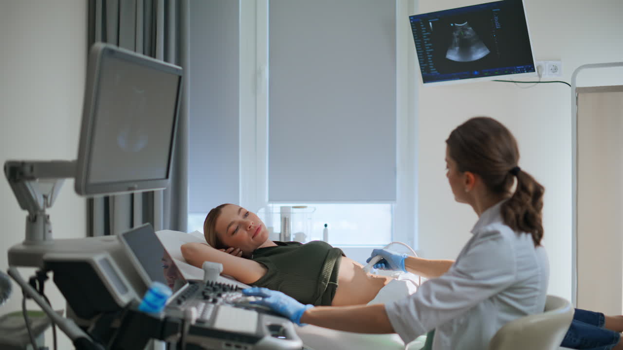 Primo piano di una donna incinta durante una visita in una clinica di screening. Futura mamma sdraiata sul divano