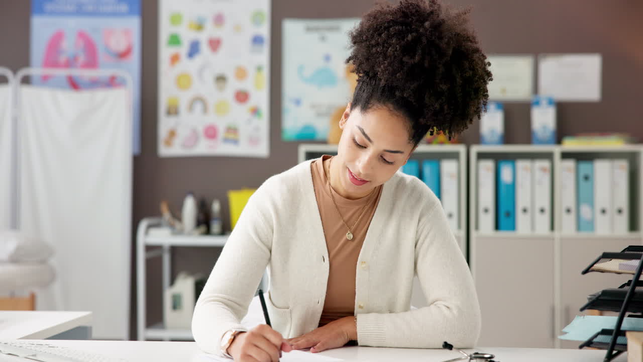 Woman writing at desk in medical office