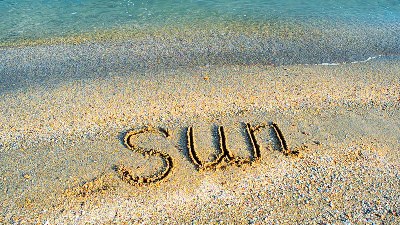 Día soleado, relajación. Inscripción del sol en la arena, la playa