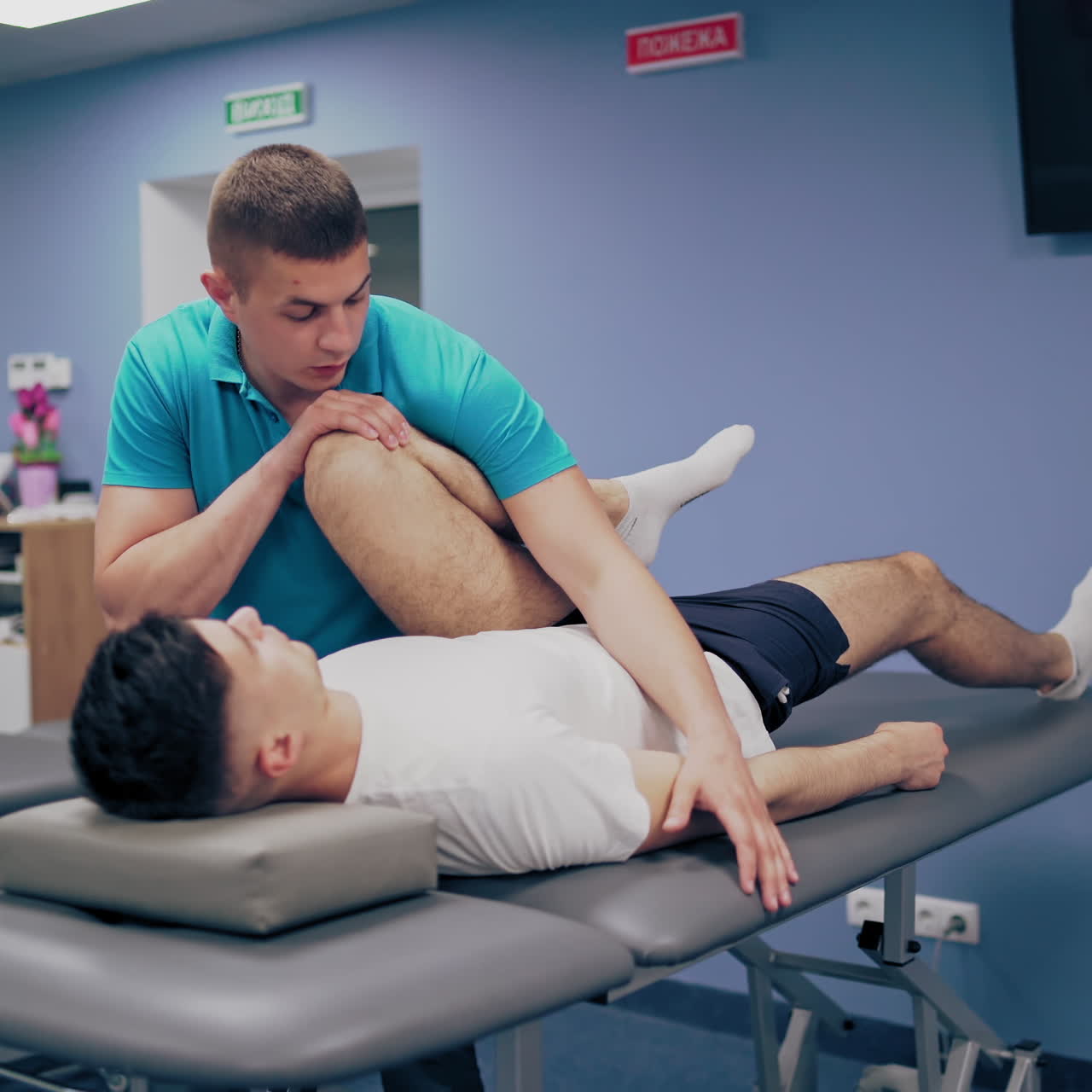 Medical specialist embedding male's leg in the rehabilitation center. Therapist worker doing massage on a patients' legs indoors.