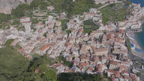 wide aerial footage that rotates around the town of amalfi among the mountains of the amalfi coast italy