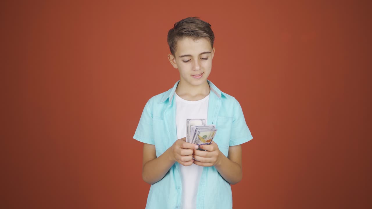 Niño contando dinero mirando a cámara