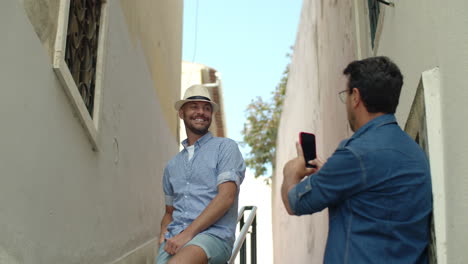 medium shot of handsome gay taking picture of boyfriend outdoor