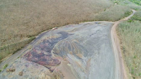 camión pesado que transporta tierra seguido de un tractor que rega el suelo