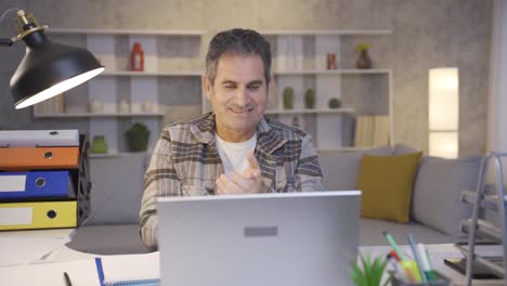 Mature-man-working-in-home-office-looking-at-laptop-and-clapping-wow.