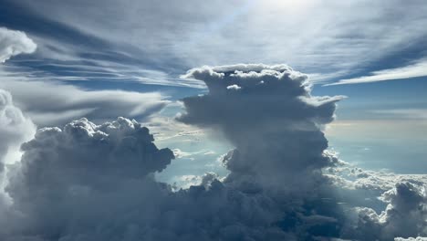 amazing aerial view from the cockpit of a jet flying between huge cumulonimbus clouds