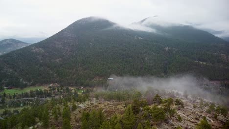 Aerial-view-of-cloud-coming-over-mountain-ridge,-estes-park,-colorado,-eagle-cliff-mountain