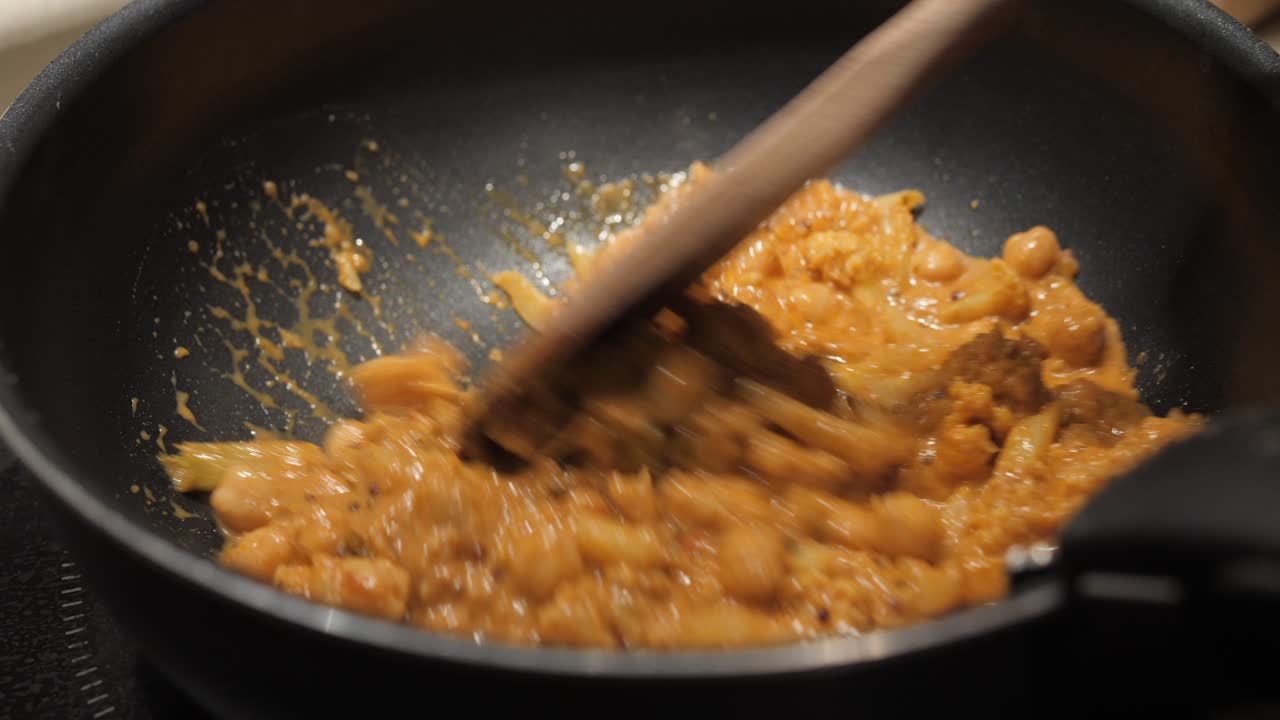 Close up shot of Indian curry cooking in pan