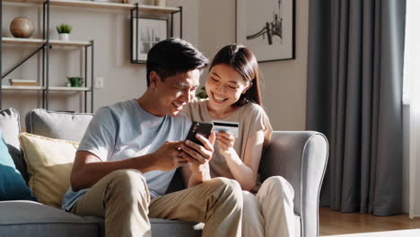 Couple making an online purchase with a credit card and smartphone