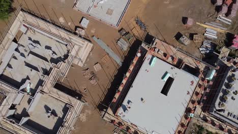 Rotating-descending-aerial-view-of-the-early-stages-of-new-build-houses-under-construction,-levelling-up-in-the-UK,-new-build-homes,-housing-development