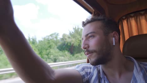 Young-man-listening-to-music-with-his-modern-wireless-headphones.