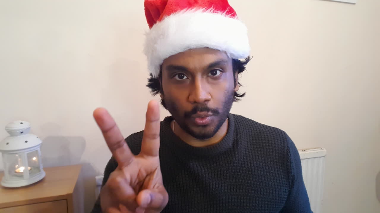 제스처 게임 중에 단어를 추측하려고 시도하는 크리스마스 화상 통화의 젊은 남자