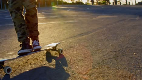 Low-section-of-young-skateboarder-skating-on-country-road-4K-4k