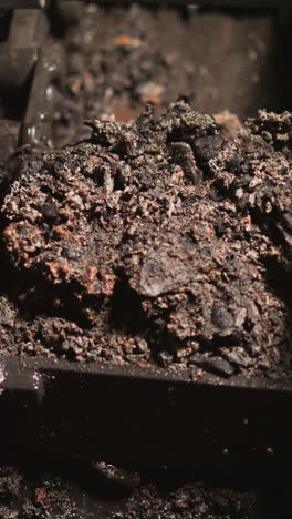 transporting wet coal slag with automatic chain conveyor closeup. used fossil fuel leftovers removing from heating furnace in industrial factory workshop