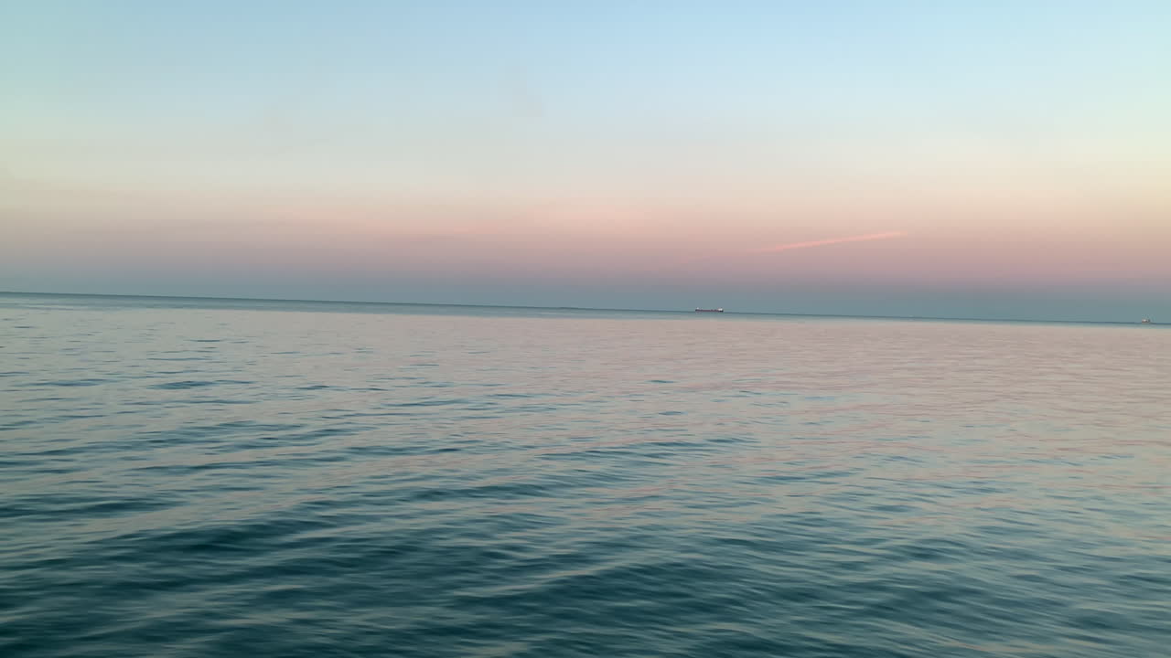 Beautiful sunset over the sea, calm waves on the sea, orange sky on the horizon, dreamy end of the day