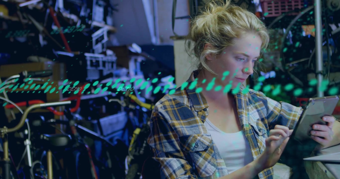 Lifting tablet, plaid-shirted woman responding to green overlay and checking repairs at bike shop