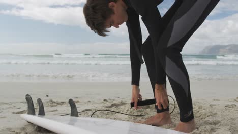 Junger-Mann-Am-Strand-Bereitet-Sich-Auf-Das-Surfen-Vor