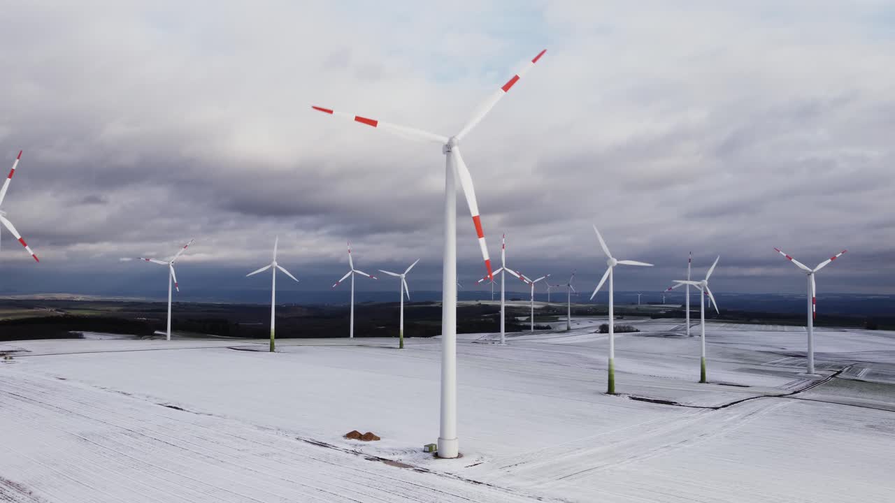 낮에 서리가 내리고 얼어붙은 겨울 풍경 동안 녹색 에너지를 위한 아름다운 생태 풍력 터빈 농장의 공중 트럭