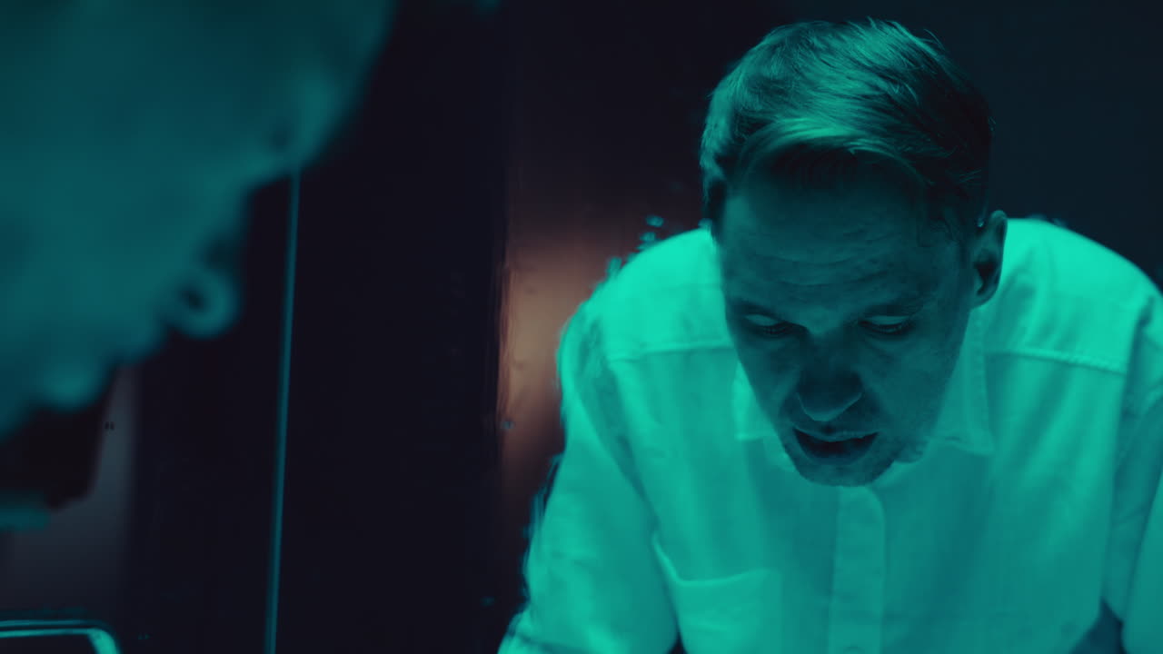 Man looking in a mirror in a dark room