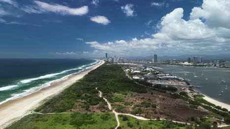 Aerial-view-of-a-nature-corridor-leading-to-a-towering-urban-city-skyline