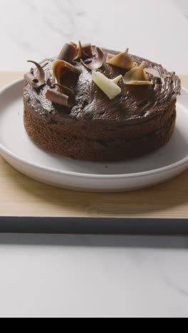 video vertical de pastel de chocolate casero en un plato en la superficie de trabajo de la cocina