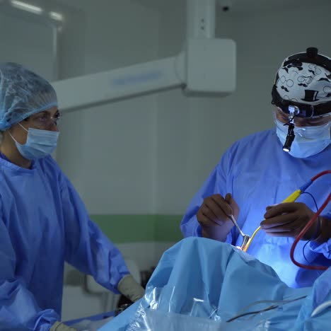 surgical process with the help of new medical equipment. contemporary equipment in the operating room. specialists in blue uniform perform an operation