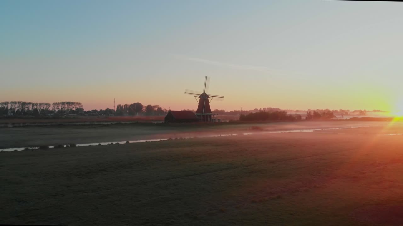Vista aerea del mulino a vento Het Prinsenhof in un prato nebbioso all'alba a Zaandam, Paesi Bassi