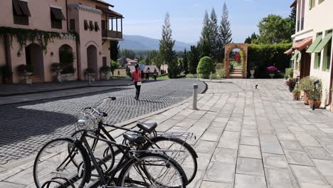 people and bicycles in a sunny courtyard setting