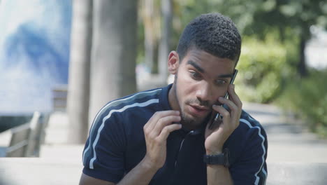 Concentrated-man-talking-on-phone-outside,-looking-shocked