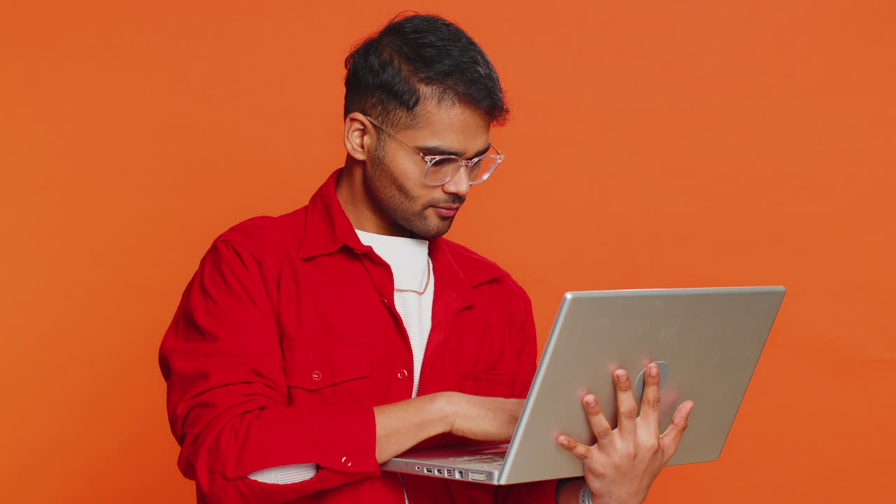 Excited happy indian man working on laptop winning online lottery game celebrating success victory