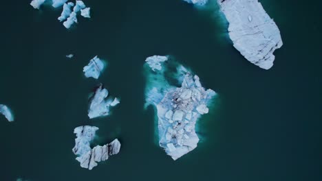 aerial ascent of iceberg ice blocks floating on polar region blue lake