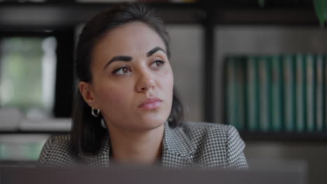 Arabian-Hispanic-woman-working-financial-paperwork-seated-at-workplace-using-laptop-looks-concentrated-while-makes-task-prepare-check-report-having-fruitful-workday.-Student-learning-process-concept